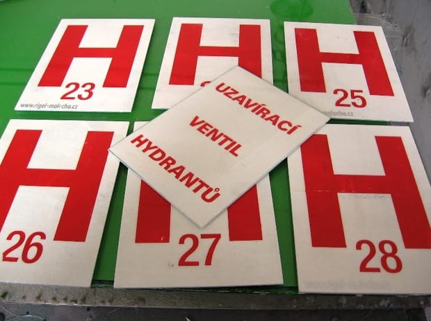 Ukázka speciálního provedení Značek Hasičů (HZS) v červeno-bílém provedení s čísly, speciálně upravené pro hasičské použití. Zahrnuje specifické prvky pro hasičský monitoring. Certifikovaná výroba RIGEL Chomutov přizpůsobená požadavkům HZS.